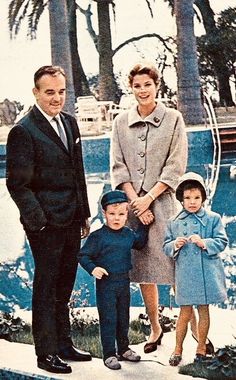 an old photo of three people and two children standing in front of a swimming pool