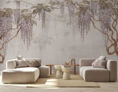 a living room with two couches and a coffee table in front of a wall mural