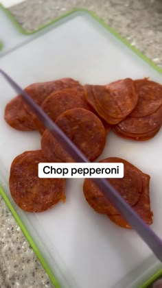 chopping pepperoni slices on a cutting board