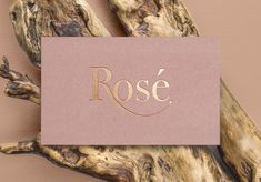 a piece of paper with the word rose on it sitting on top of a tree branch