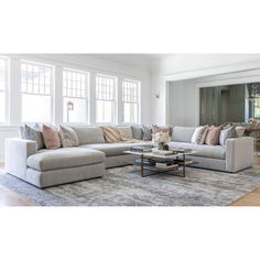 a living room filled with lots of furniture next to a large white couch and coffee table