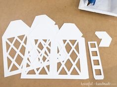 cut out pieces of paper sitting on top of a table next to a paintbrush