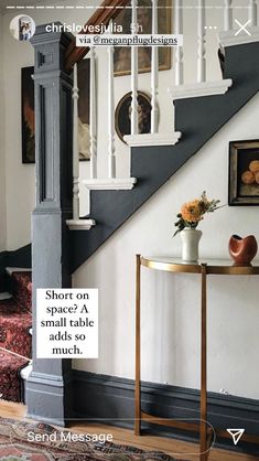 a white and black staircase with flowers on the side table next to it in a living room