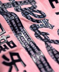 a pink shirt with black and white designs on it