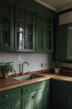 a kitchen with green cabinets and wooden counter tops