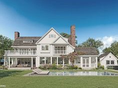 a large white house sitting on top of a lush green field next to a swimming pool