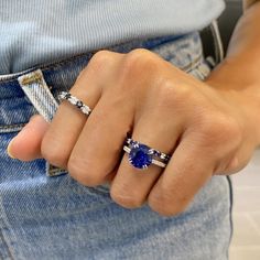 a woman's hand with two rings on it and a blue stone in the middle