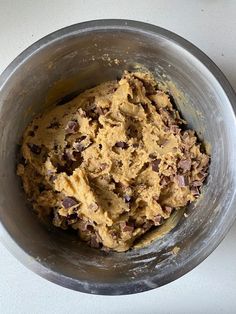 a metal bowl filled with batter and chocolate chips