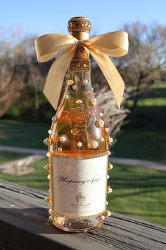 a bottle of wine sitting on top of a wooden table next to a green field