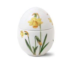 a white egg with yellow flowers painted on it