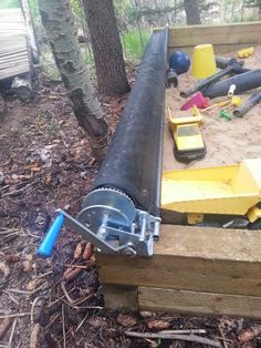 a pipe laying on top of a wooden box in the woods