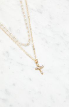 The LA Hearts Pearl Rhinestone Cross Necklace embodies elegance and style with its layered design, adorned with pearl and rhinestone accents. Featuring gold hardware and a delicate cross charm, this necklace offers a timeless aesthetic, complete with an adjustable lobster clasp closure for a perfect fit.


	Gold layered necklace
	Pearl beads
	Cross charm
	Adjustable lobster clasp closure Pretty Cross Necklace, Cute Cross Necklace, Cross Necklace Aesthetic, Juliet Costume, Pearl Cross Necklace, Cross Necklace Women, Gold Layered Necklace, Layered Pearl Necklace, Timeless Aesthetic