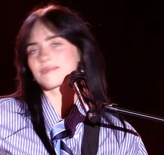 a woman wearing a tie and holding a microphone