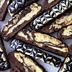 chocolate cookies with white and black swirls on them are arranged in a square pattern