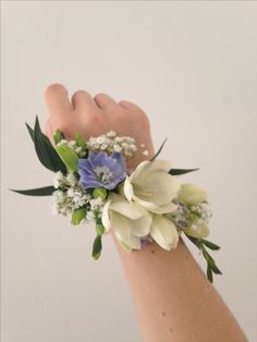 a person's arm with flowers and leaves attached to it, on a white background