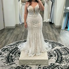 a woman taking a selfie in front of a mirror wearing a wedding dress and holding an umbrella