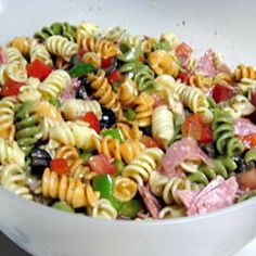 a white bowl filled with pasta salad on top of a table