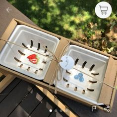 an open box with utensils in it sitting on a wooden table next to grass