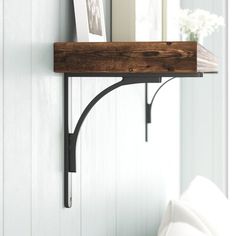 the shelf is made out of wood and has metal brackets on it, along with books