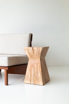 a wooden chair sitting next to a couch on top of a white floor covered in furniture