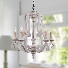 a white chandelier with candles hanging from it