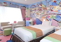 a hello kitty themed bedroom with two beds and colorful wallpapers on the walls