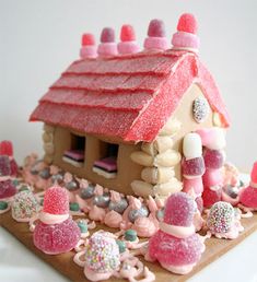 a gingerbread house with pink frosting and candy decorations on it's roof