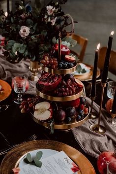 the table is set with fruit and candles