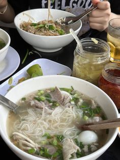 a table topped with bowls filled with soup and veggies