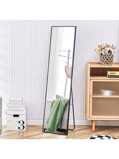 a large mirror sitting on top of a wooden floor next to a dresser and chair