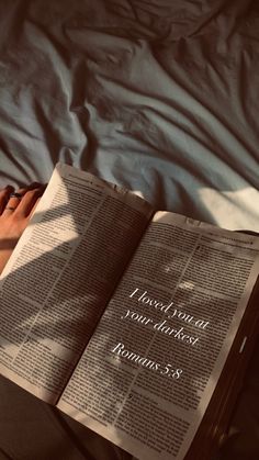 a person laying in bed reading a book with their feet up on top of the book