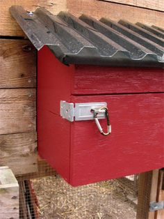 a red bird house with a metal roof