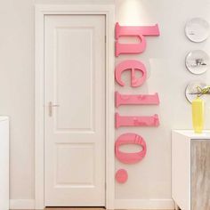 there is a pink sign on the wall next to a door that says hello written in cursive letters