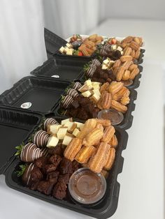 several trays filled with chocolate covered pastries and other dessert items on a table