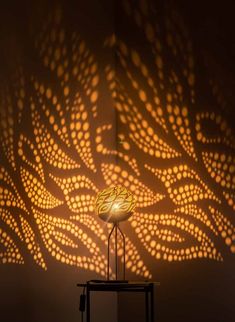 a lamp that is on top of a table in front of a wall with lights