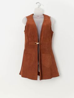 Vintage long suede waistcoat in tan brown. This 1960/70s stunning tan brown long suede vest features a gold buckle closure, a V-neck and two pockets above the hem. Made from a heavyweight butter soft suede. Our recommended size: Medium Label says: No size label Condition: Very good* Material: 100% suede Measurements in inches: Pit to pit: 18 Shoulders: 14.5 Front length: 31.5 Back length: 31.5 Hem: 23.5 *Imperfections, scars, shadings, blemishes enhance the beauty and value of this genuine leath Vintage Brown Sleeveless Outerwear, Suede Waistcoat, Suede Vest, Gilet Long, Vest Outfits, Size Label, Western Outfits, Soft Suede, Tan Brown