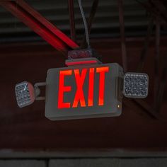 an exit sign hanging from the ceiling with red light on it's sides and two lights at the bottom