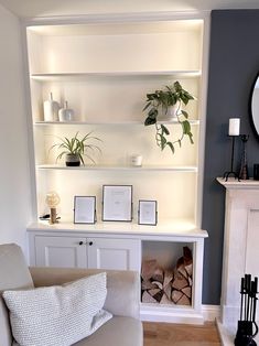 a living room filled with white furniture and lots of plants on top of the shelves