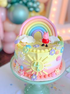 there is a cake that has been decorated with flowers and rainbows on it,