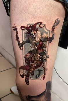 a man's leg with an image of a skeleton on it and a demon