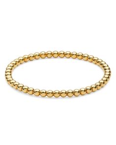 a gold beaded bracelet on a white background