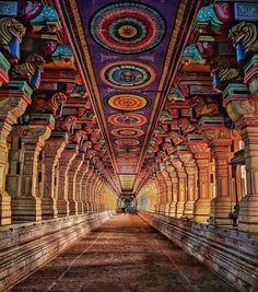 the inside of an ornate building with many pillars and arches on each side, all painted in different colors