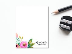 an image of a notepad with flowers on it and a pencil next to it