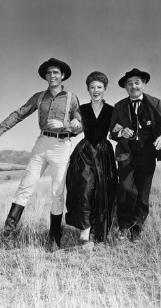 three people are posing for a photo in an old fashioned western style dress and hat