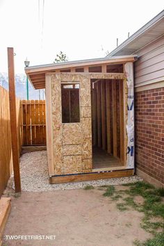 a small shed is being built in the back yard with wood framing and siding on the walls