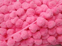 a pile of pink pom - poms sitting on top of a white table