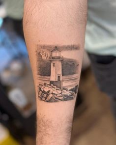 a man with a lighthouse tattoo on his arm