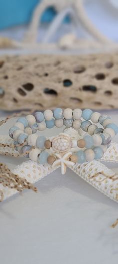 TitiTataStore.etsy.com Always FREE SHIPPING and a FREE GIFT! I Will Ship Within 24 Hours! Description: A set of 2 Coastal Style Beach Bracelets. The perfect accessory for that beach getaway vacation trip!  Materials:  8mm Sea Sediment Jasper Beads, 8mm Natural Wood Beads, 8mm Faceted Aquamarine Blue Rondelle Quartz Beads, and 6mm Sandalwood Beads.  A Sea Turtle and a Starfish charm adorned this Coastal style  set.  A high-quality elastic stretch cord is used to string the beads together.  Size: Sea Jewelry Aesthetic, Pretty Beaded Jewelry, Aesthetic Bracelets, Beachy Bracelets, Sand Gifts, Ocean Bracelet, Girls Trip Gifts, Braided Bracelet Diy, Sea Turtle Bracelet