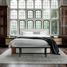 a bedroom with large windows and a white bed in it's centerpieces