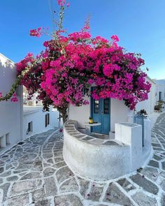 a white house with pink flowers on the outside